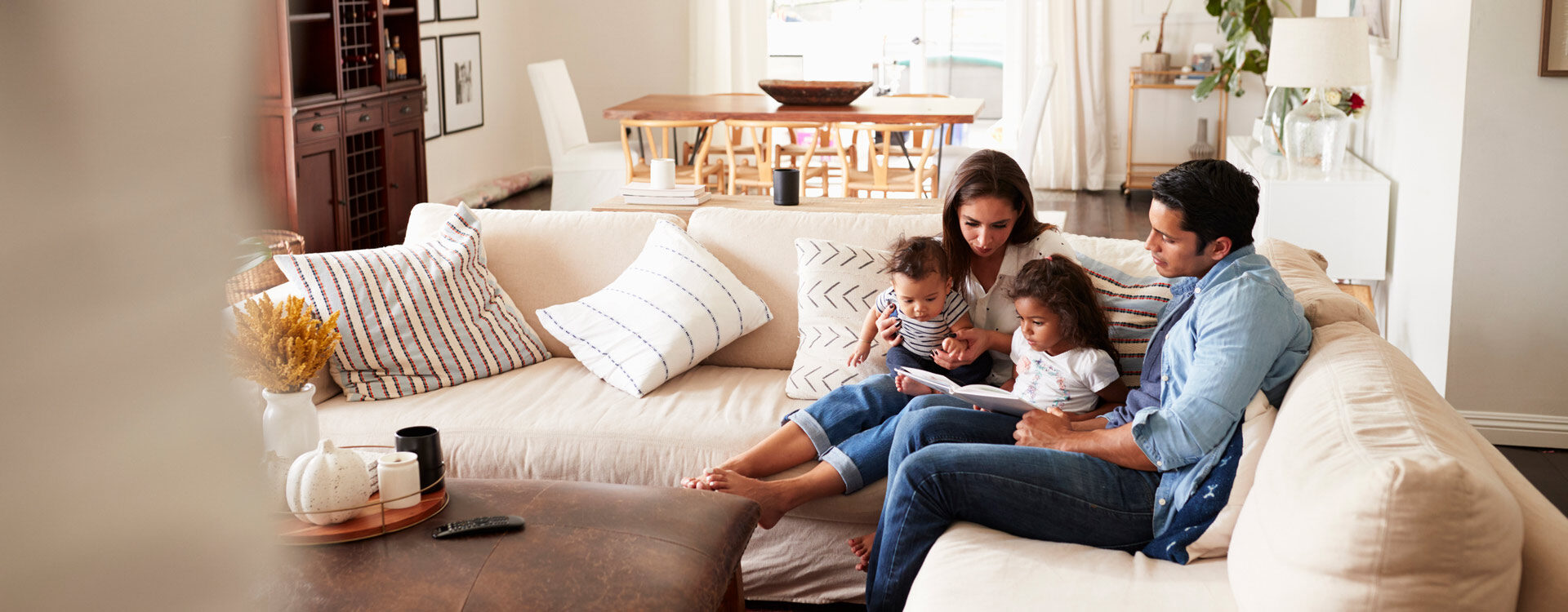 Family sitting together on a sofa reading a book Family sitting together on a sofa reading a book